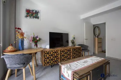 a living room with a table and a television at Air-conditioned apartment near Libération district in Nice