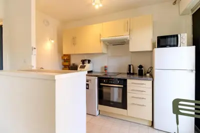 a kitchen with white appliances and a white refrigerator at Cozy Apt with balcony - Garibaldi Port in Nice