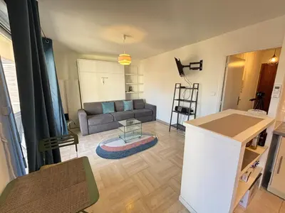 a living room with a couch and a table at Cozy Apt with balcony - Garibaldi Port in Nice
