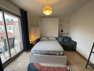 a bedroom with a bed and a couch and a window at Cozy Apt with balcony - Garibaldi Port in Nice