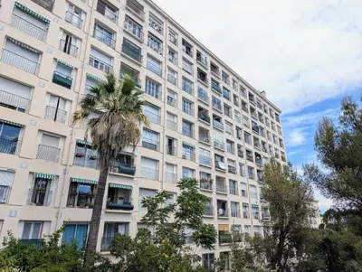 a tall building with a palm tree in front of it at Appartement SEA-Azur panorama Nice Fabron in Nice