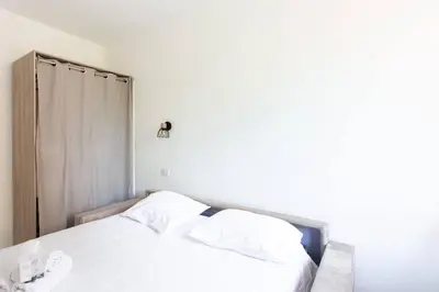 a white bed with white sheets and pillows at LYMPIA -Cosy studio, 200 m plages de Nice - Le Port in Nice