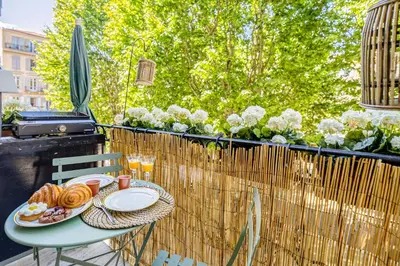 a table with plates of food on a balcony at New! Remodeled Appartement in the Heart of Nice, Beach 3 min, 2BR, AC, Elevator, Amazing little terrace, Best Location! in Nice