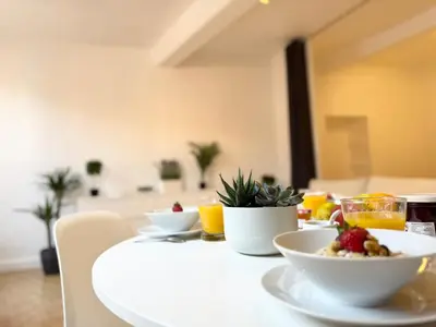 a white table with a bowl of fruit on it at Charmant 2 pièces proche mer in Nice