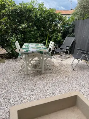 a table and chairs sitting on a gravel patio at Studio 100m plage in Cagnes-sur-Mer