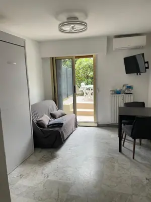 a living room with a chair and a table at Studio 100m plage in Cagnes-sur-Mer
