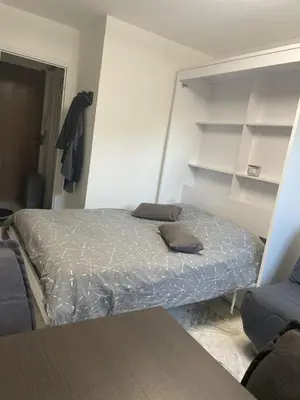 a bedroom with a bed and shelves on the wall at Studio 100m plage in Cagnes-sur-Mer