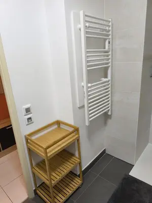 a small refrigerator with a wooden shelf in a room at Studio calme et paisible, climatisé avec terrasse au dernier étage, 100m du tramway et 20 min de la promenade des anglais in Nice