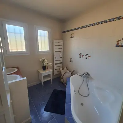 a bathroom with a tub and a toilet and a sink at Le flamand in Tourrette-Levens