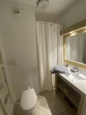 a bathroom with a toilet and a sink and a mirror at Charming studio with swimming pool in Nice