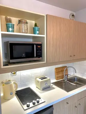 a kitchen with a microwave and a sink at Charming studio with swimming pool in Nice