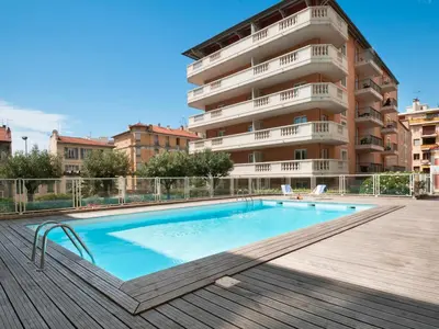 a swimming pool in front of a building at Charming studio with swimming pool in Nice