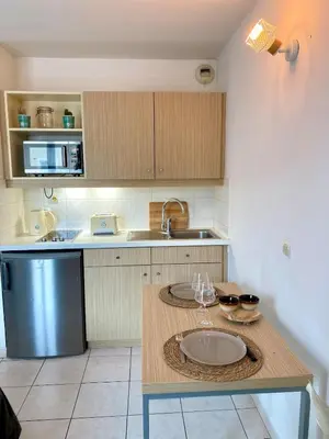 a kitchen with a table with a sink and a counter top at Charming studio with swimming pool in Nice