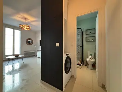 a bathroom with a washing machine in the middle of a room at Studio 2 Libération proche tram in Nice