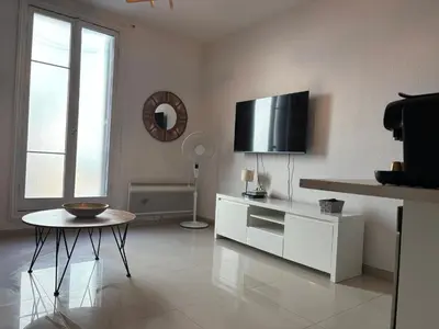 a white living room with a tv on the wall at Studio 2 Libération proche tram in Nice