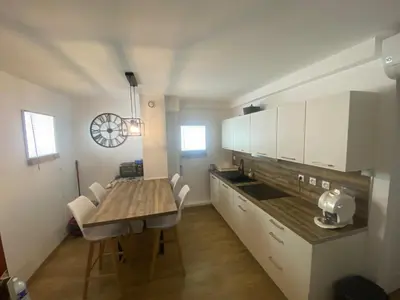 a kitchen with a wooden table and a dining room at Appartement de 4 chambres proche plage, tram et aeroport in Nice