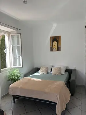 a bed in a bedroom with a picture on the wall at Cozy studio sur la promenade in Nice