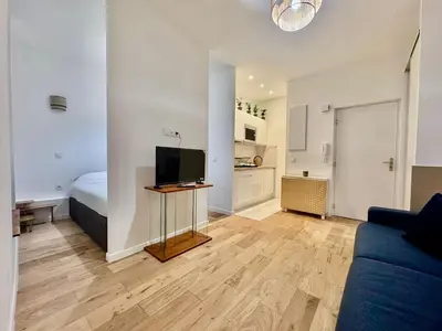 a living room with a couch and a television at Charming Studio in the Heart of Nice in Nice