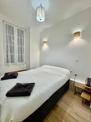 a bedroom with a large bed with two towels on it at Charming Studio in the Heart of Nice in Nice