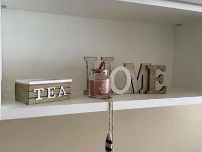 a shelf with a tea bottle and the words tea one at Azur Promenade in Nice