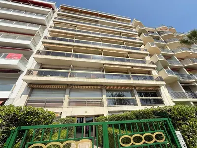 a tall building with a green gate in front of it at Azur Promenade in Nice