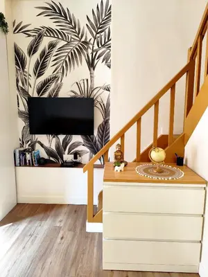 a living room with a staircase with a tv on a wall at Tribord Holiday House in Nice