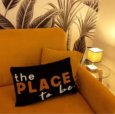 a black pillow sitting on a couch with a wall at Tribord Holiday House in Nice