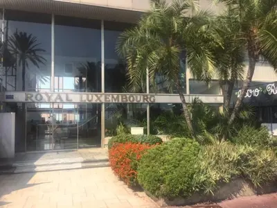 a building with palm trees and flowers in front of it at Studio et ses deux piscines in Nice