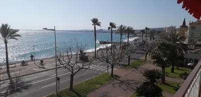 a view of a street and the ocean with palm trees at Stella Maris in Cagnes-sur-Mer