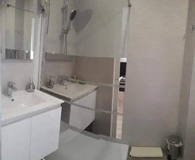 a white bathroom with two sinks and a shower at Stella Maris in Cagnes-sur-Mer