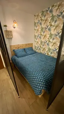 a bedroom with a bed with a blue comforter at Appartement proche plage, aéroport, tram in Nice
