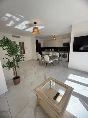 a living room with a table and a dining room at Magnifique 3 pièces à 100m de la mer in Nice