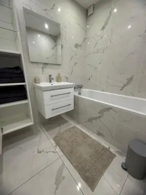 a white bathroom with a tub and a sink at Magnifique 3 pièces à 100m de la mer in Nice