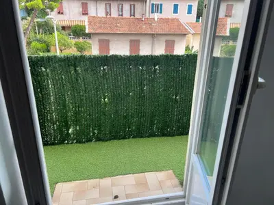 a window view of a yard with a fence at Studio tout équipé in Nice