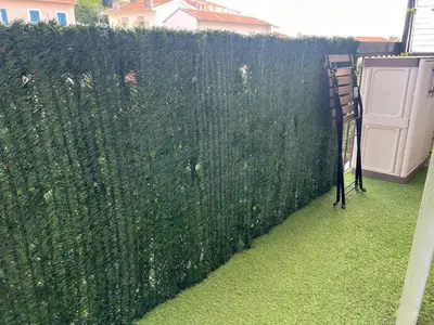 a fence with green plants on the side of it at Studio tout équipé in Nice