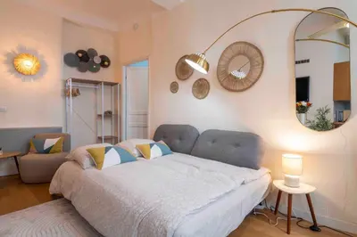 a bedroom with a bed and a large mirror at Charming flat, fully equipped, air conditioning, beach only 300m - LA LOGE in Nice
