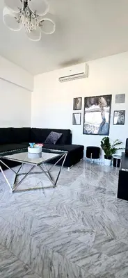 a living room with a black couch and a table at Top Floor with Sea View, Clim and Veranda in Nice