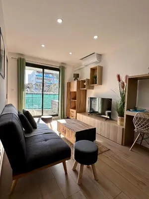 a living room with a couch and a table at Appartement Zephyr - à 1 minute de la plage in Cagnes-sur-Mer