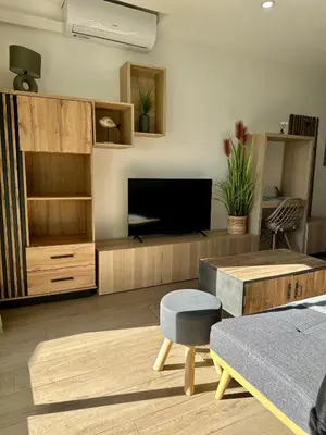 a living room with a tv and a couch and a table at Appartement Zephyr - à 1 minute de la plage in Cagnes-sur-Mer