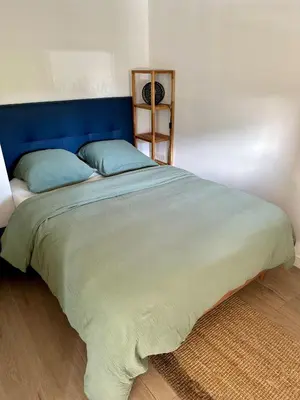 a large bed with a blue headboard in a bedroom at Appartement Zephyr - à 1 minute de la plage in Cagnes-sur-Mer