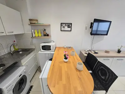 a small kitchen with a wooden table and a microwave at Sunny Prom Studio in Nice