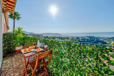 a table and chairs on a balcony with a view of the ocean at Panoramic sea view of the French Riviera, Parking in Nice