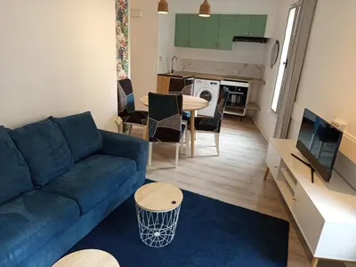 a living room with a blue couch and a table at Calme, confortable et bien placé in Nice