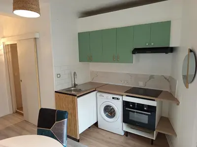 a kitchen with green cabinets and a washing machine at Calme, confortable et bien placé in Nice