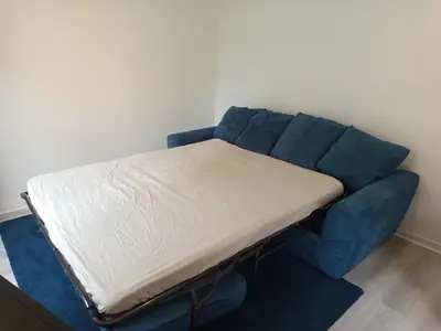a bed sitting on top of a blue couch at Calme, confortable et bien placé in Nice