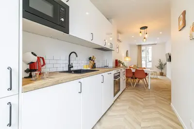 a kitchen with white cabinets and a dining room at Large & Confort 2 Bdr Renovated in Nice