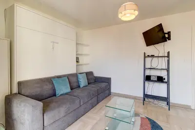 a living room with a couch and a glass table at Cozy Studio Apt with balcony close to Garibaldi in Nice