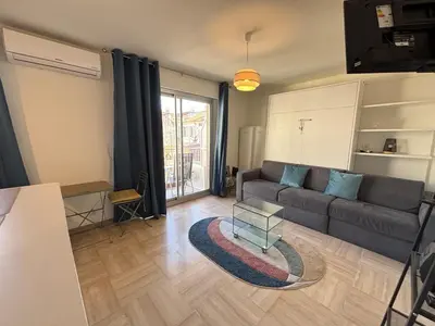 a living room with a couch and a glass table at Cozy Studio Apt with balcony close to Garibaldi in Nice