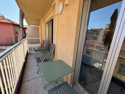 a balcony with a table and a bench and a window at Cozy Studio Apt with balcony close to Garibaldi in Nice
