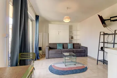 a living room with a couch and a table at Cozy Studio Apt with balcony close to Garibaldi in Nice